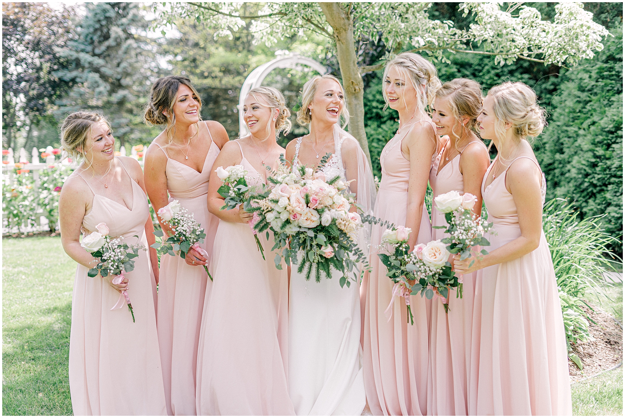 bridesmaids in blush dresses by bride