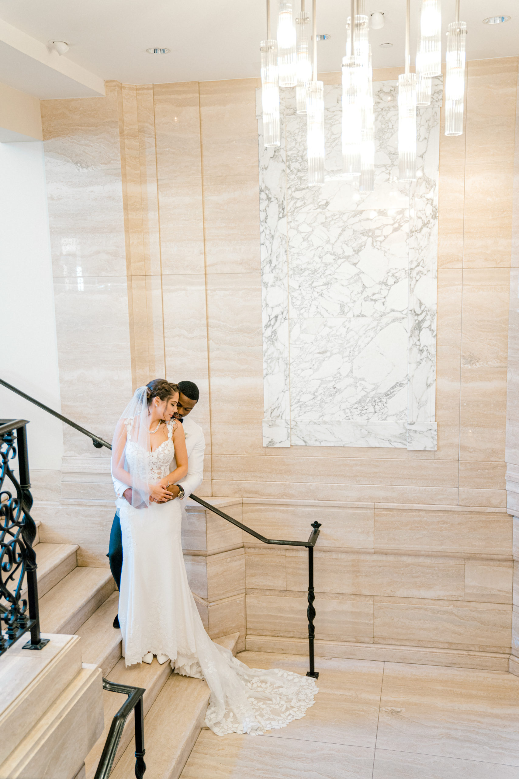 bride and groom pose on staircase of Detroit wedding venue