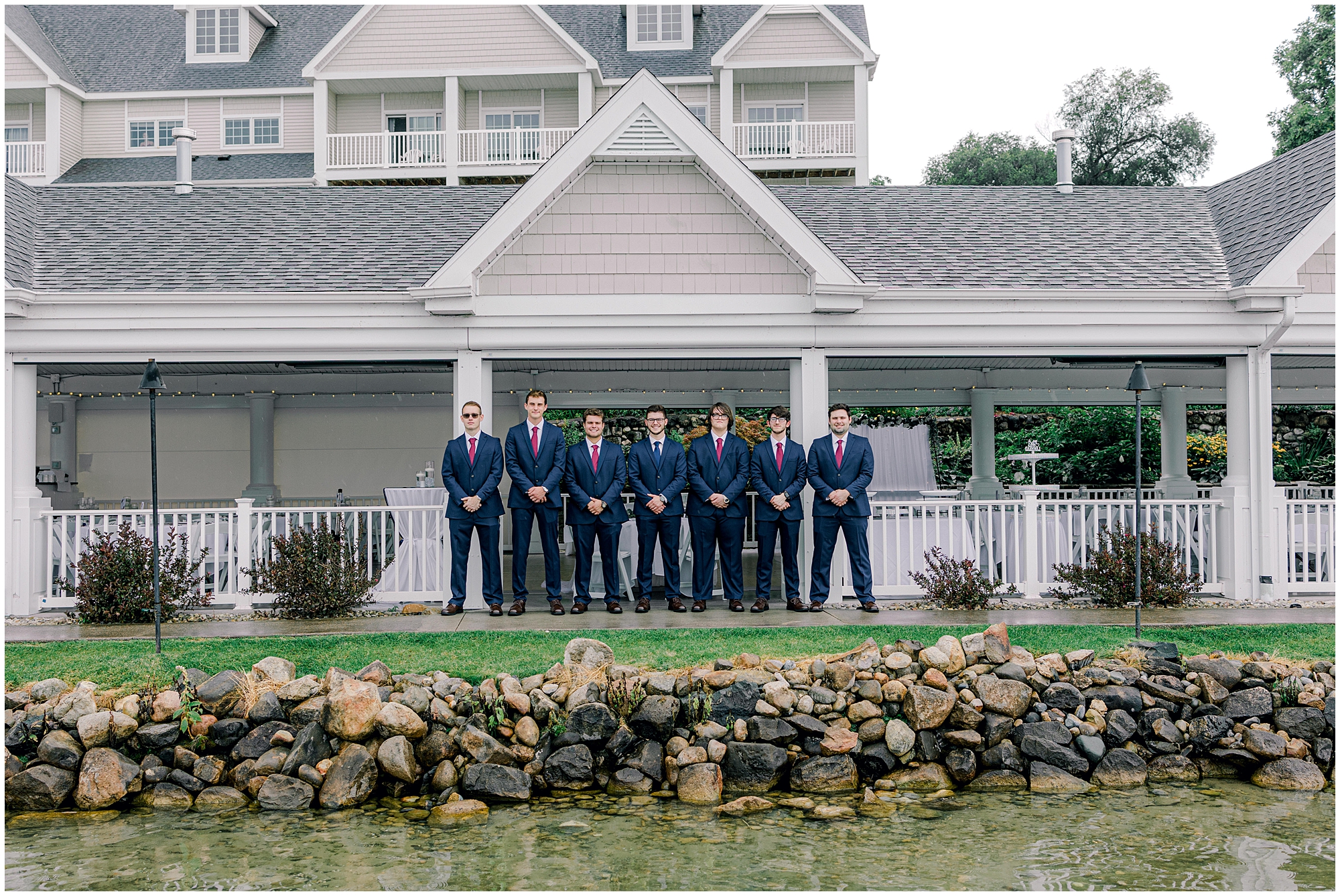 groom poses with groomsmen during outdoor wedding photos