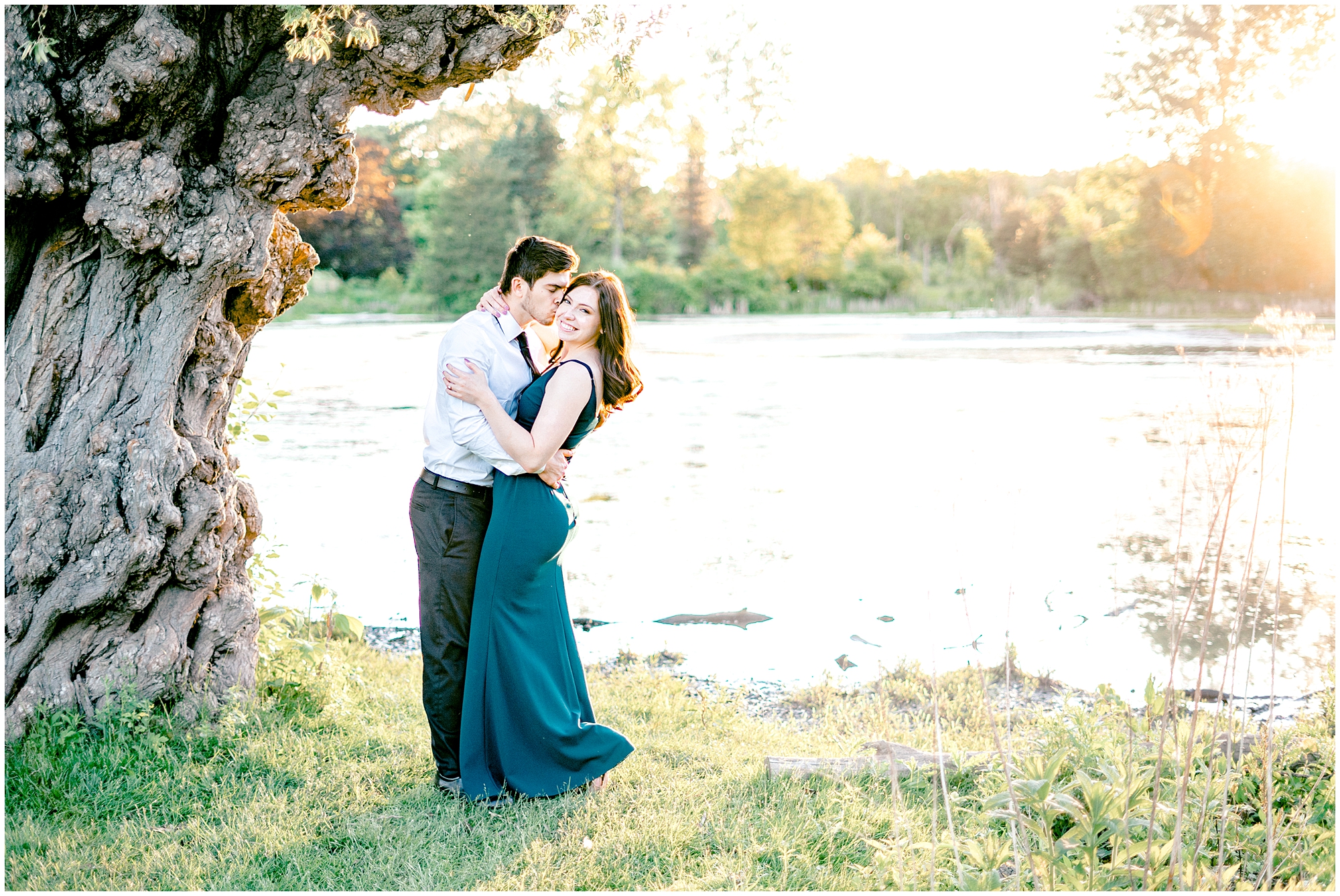 couple kisses in front of a lake
