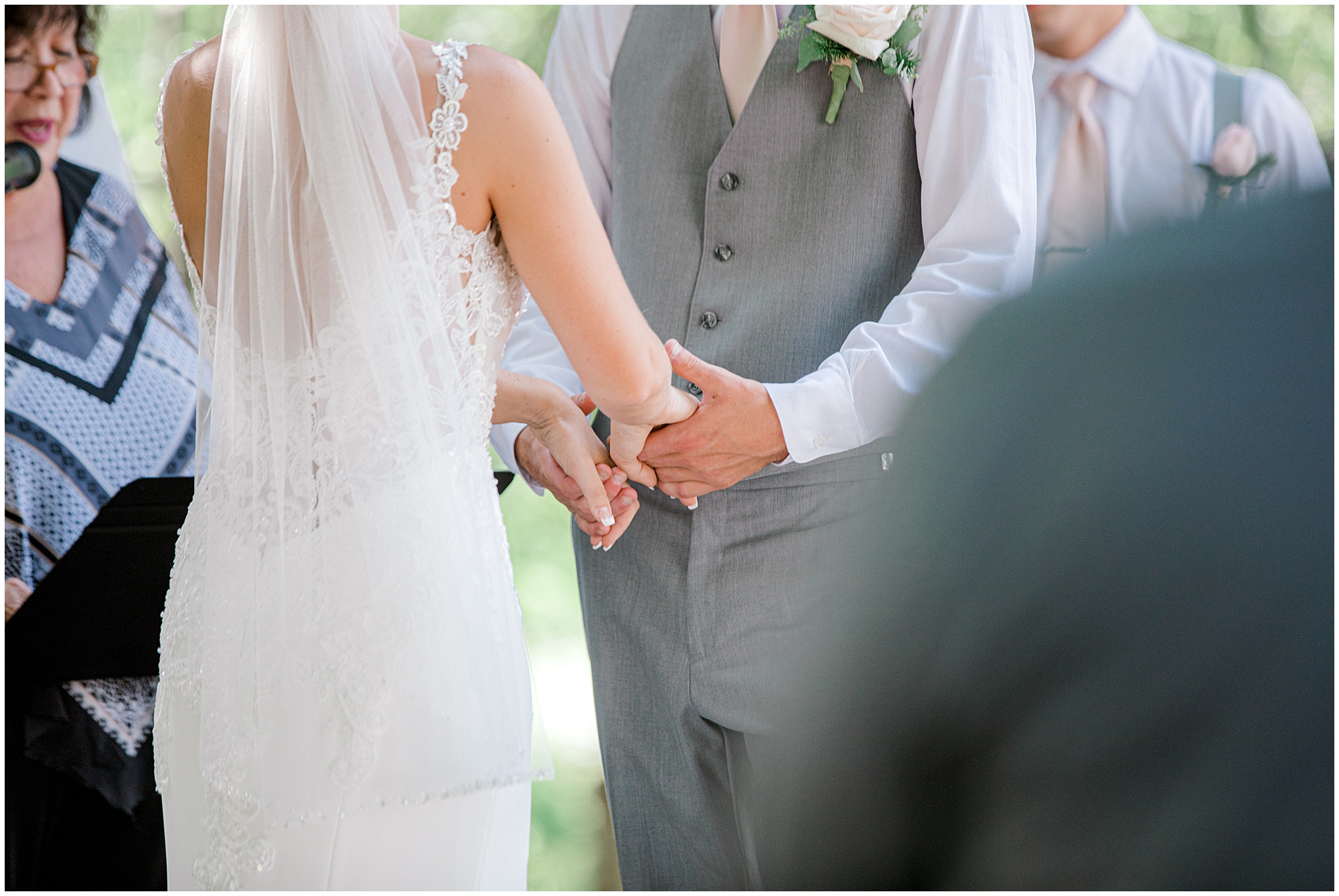 bride and groom holding hands during outdoor wedding ceremony