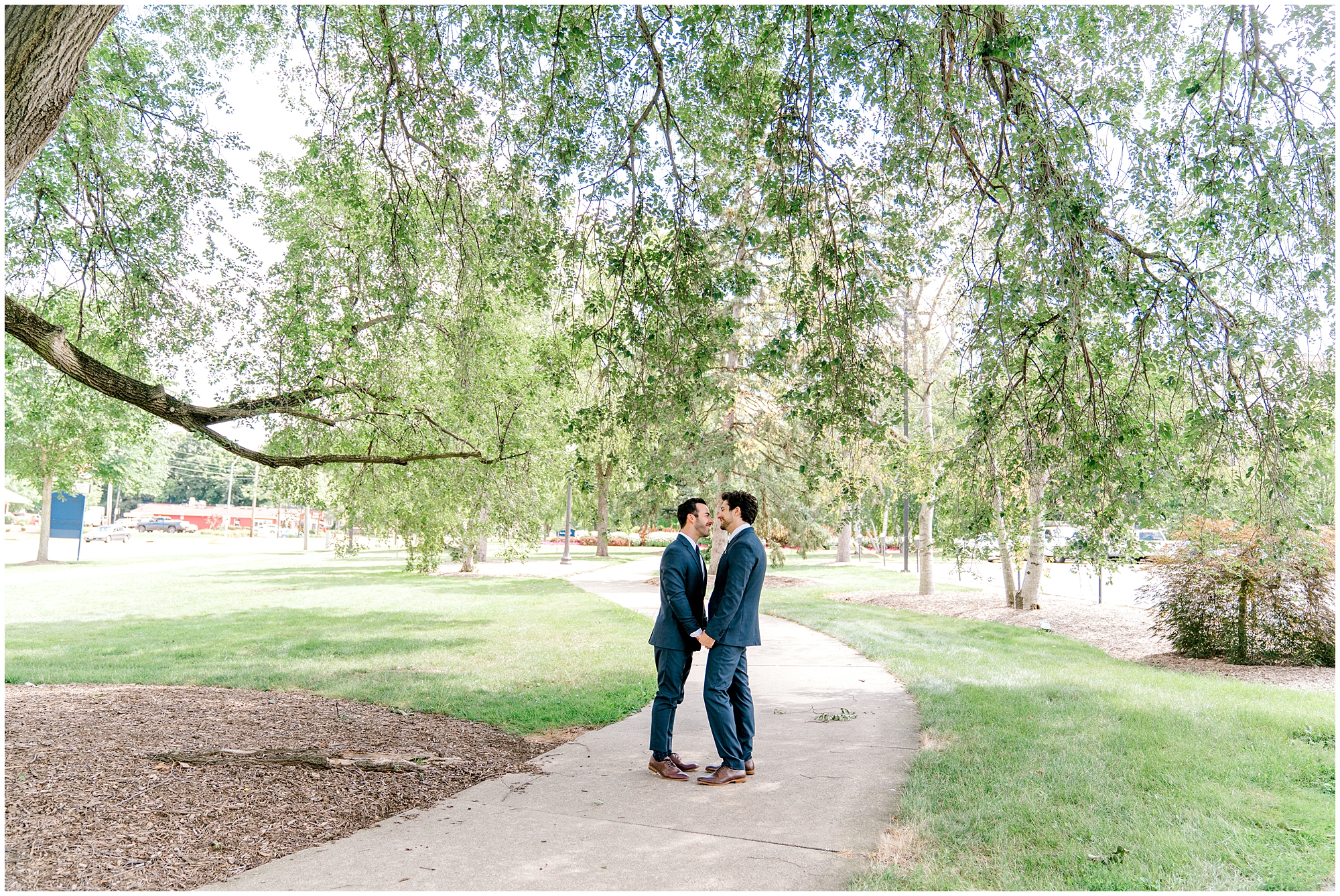 two grooms take outdoor wedding photos