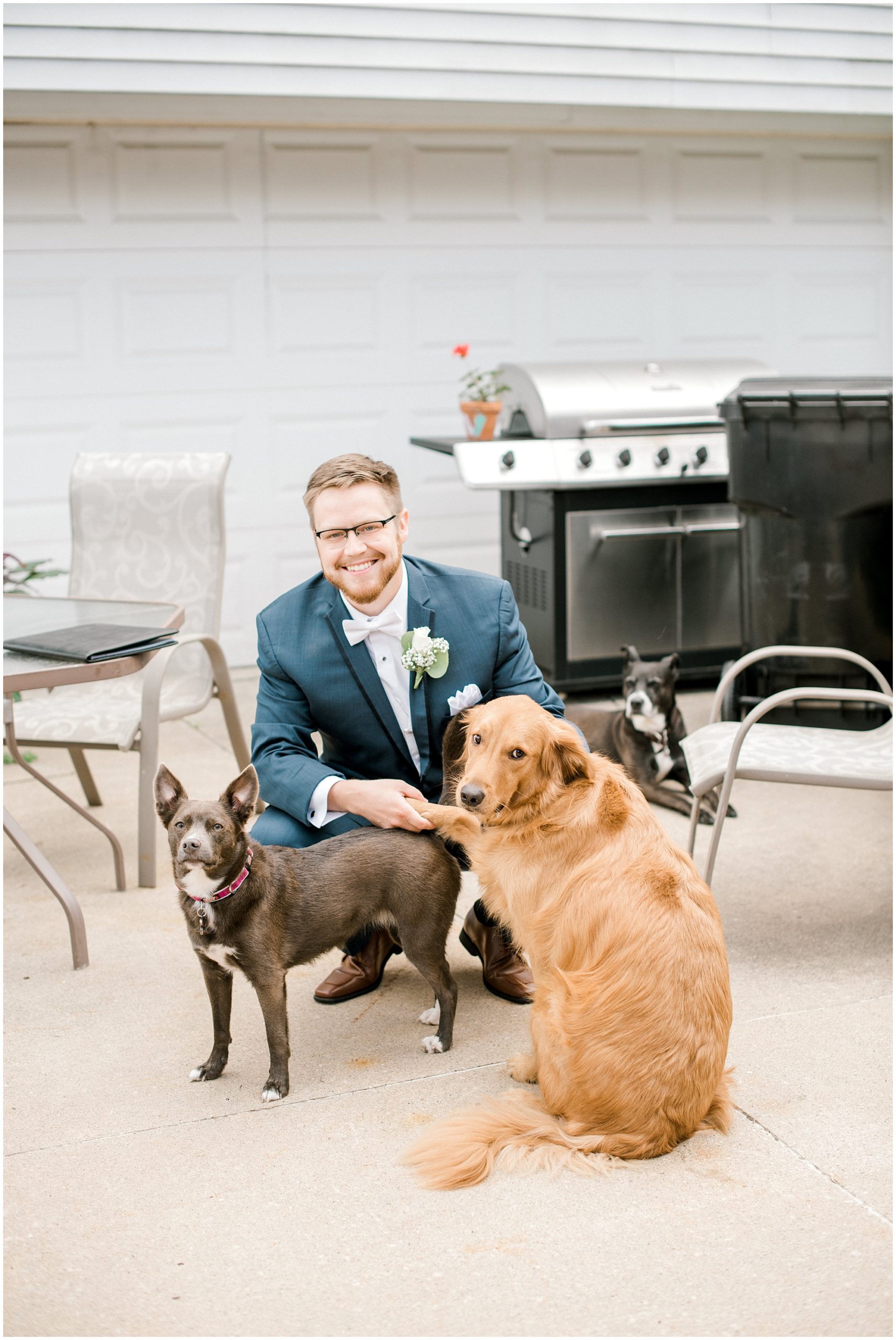 groom poses with his dogs