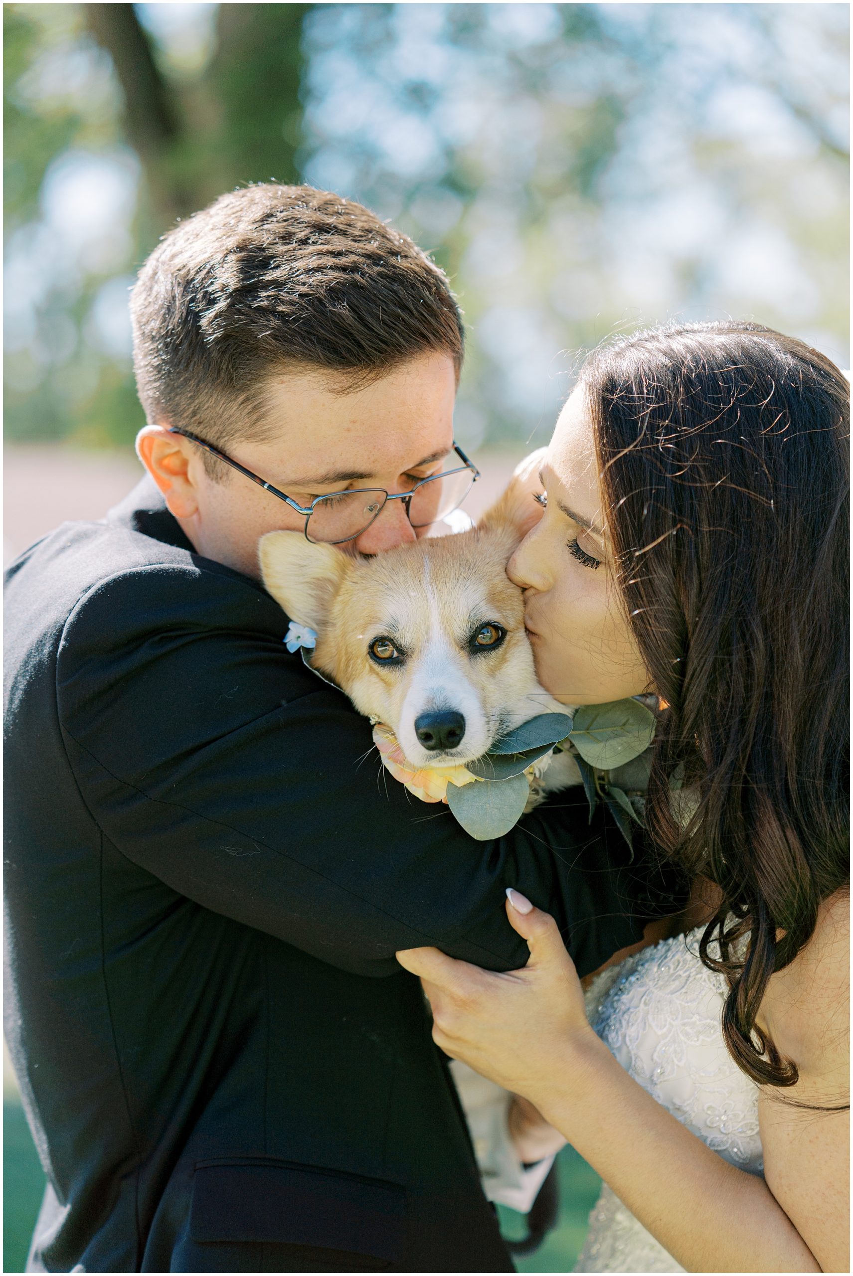 couple kisses dog in wedding photos