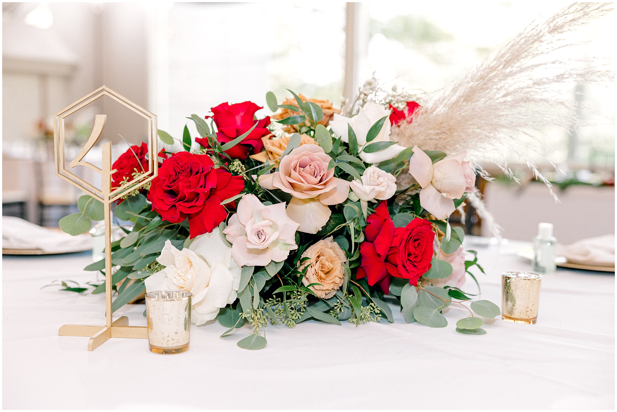 closeup of red roses and pampas grass wedding centerpieces