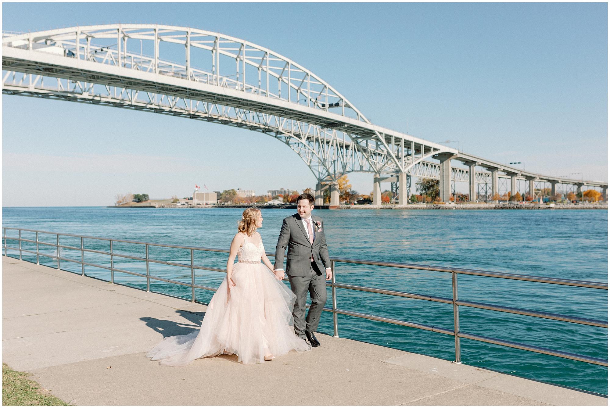 couple walks by the water - summer wedding themes in Michigan